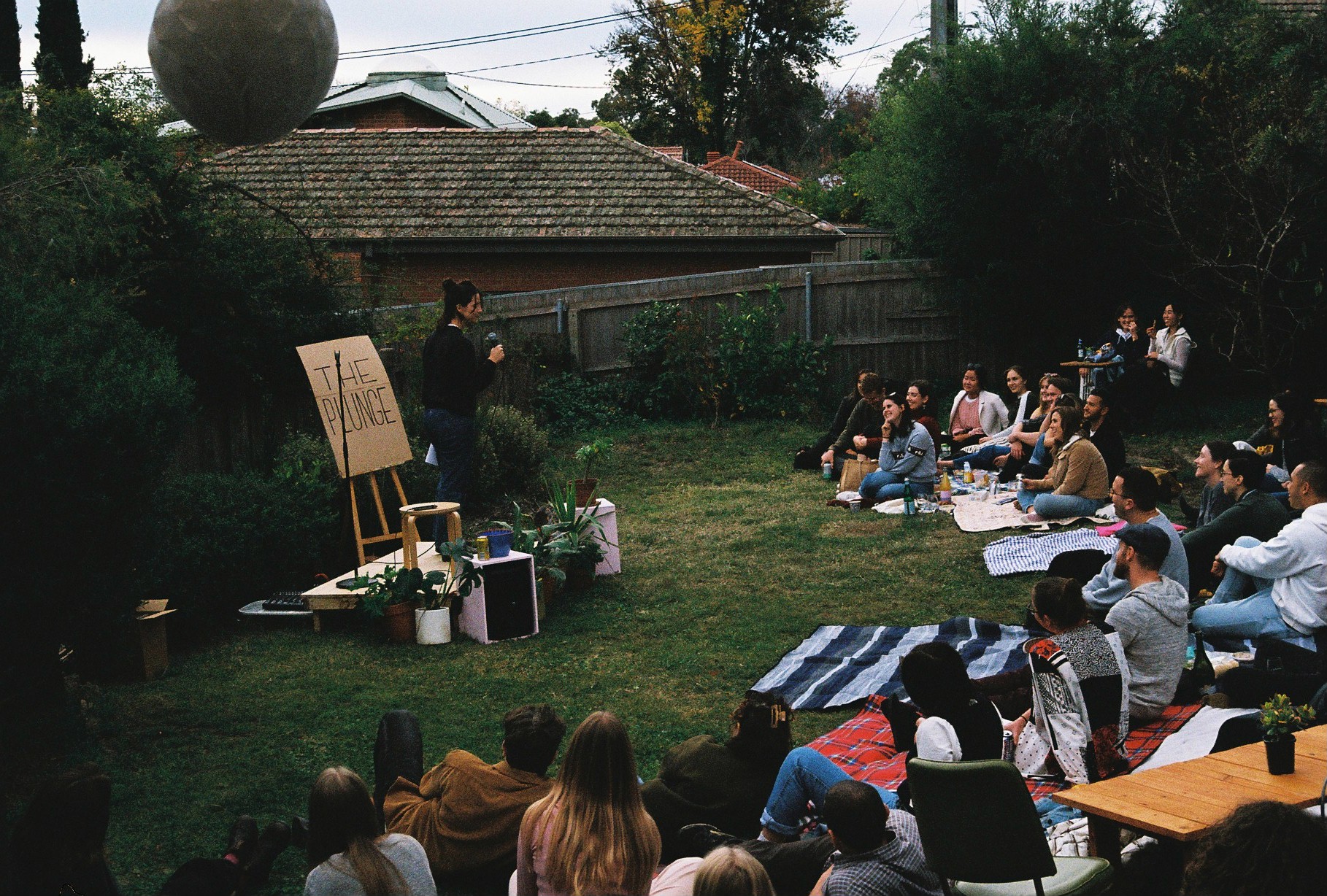 Person performing to audience in a backyard in Canberra